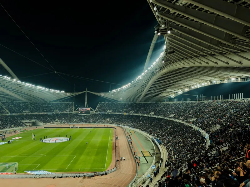 A crowded soccer stadium under bright lights at night, capturing the excitement of a live sports event. (stock photo via Pexels)